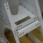 Crotch strap bracket riveted in place